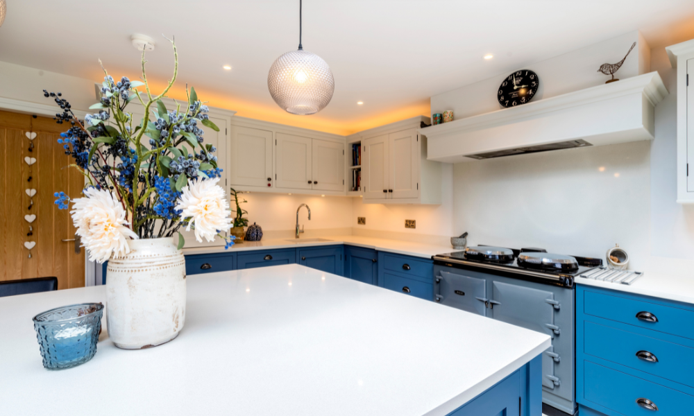 Photo of a kitchen with an island with a reconditioned dartmouth blue electric Aga cooker